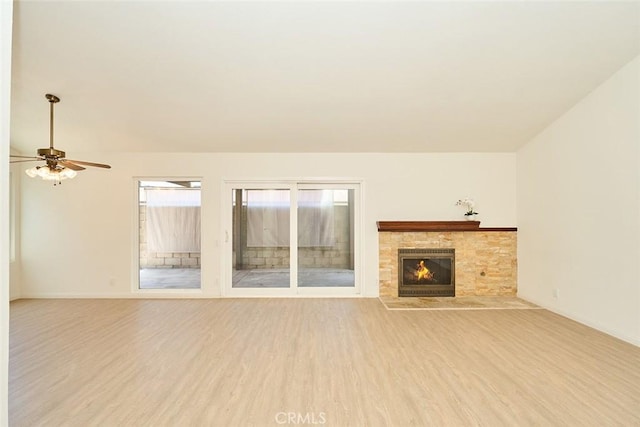 8068 Catherine Ave Unit 9, Stanton, CA 90680 - unfurnished living room featuring wood finished floors, ceiling fan, a glass covered fireplace, and baseboards
