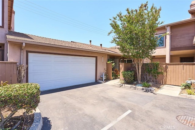8068 Catherine Ave Unit 9, Stanton, CA 90680 - view of front facade featuring fence, concrete driveway, stucco siding, and a garage