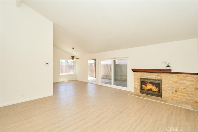 8068 Catherine Ave Unit 9, Stanton, CA 90680 - unfurnished living room with wood finished floors, vaulted ceiling, a tile fireplace, a ceiling fan, and baseboards
