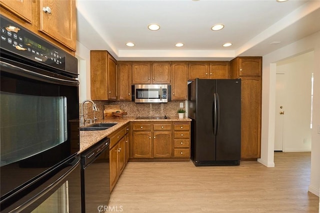 8068 Catherine Ave Unit 9, Stanton, CA 90680 - kitchen with black appliances, a sink, brown cabinetry, light wood finished floors, and tasteful backsplash