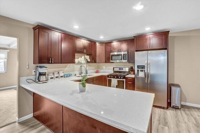 7977 Pala St, San Diego, CA 92114 - kitchen with stainless steel appliances, a peninsula, light wood-type flooring, recessed lighting, and light stone countertops