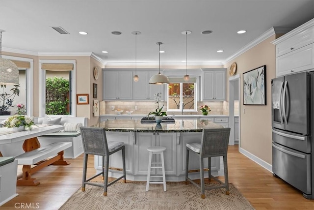 1304 Harkness St, Manhattan Beach, CA 90266 - kitchen featuring stainless steel fridge, breakfast area, light stone counters, a kitchen breakfast bar, and light wood-type flooring