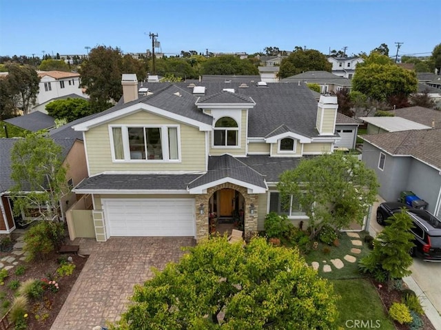 1304 Harkness St, Manhattan Beach, CA 90266 - traditional-style home featuring a shingled roof, an attached garage, a chimney, decorative driveway, and stone siding