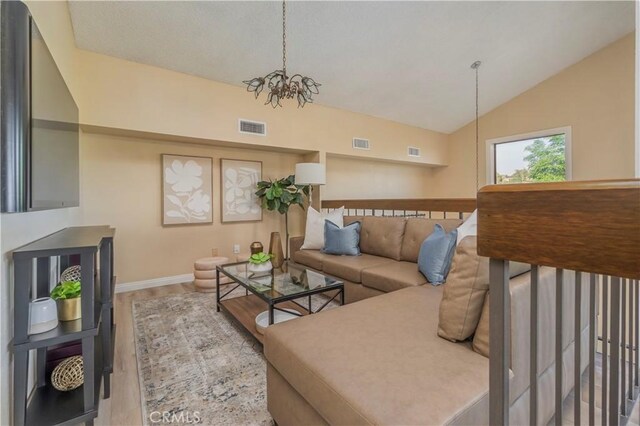 9403 Mesa Robles Dr, Whittier, CA 90603 - living area with a chandelier, lofted ceiling, wood finished floors, and baseboards