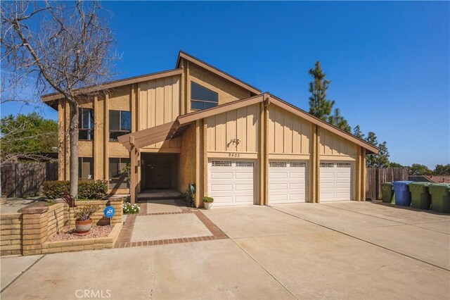 9403 Mesa Robles Dr, Whittier, CA 90603 - view of front of home featuring board and batten siding, fence, driveway, and a garage