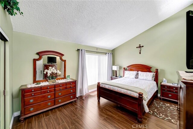 7226 Jordan Ave Unit 6, Canoga Park, CA 91303 - bedroom with vaulted ceiling, a textured ceiling, dark wood-style floors, and baseboards