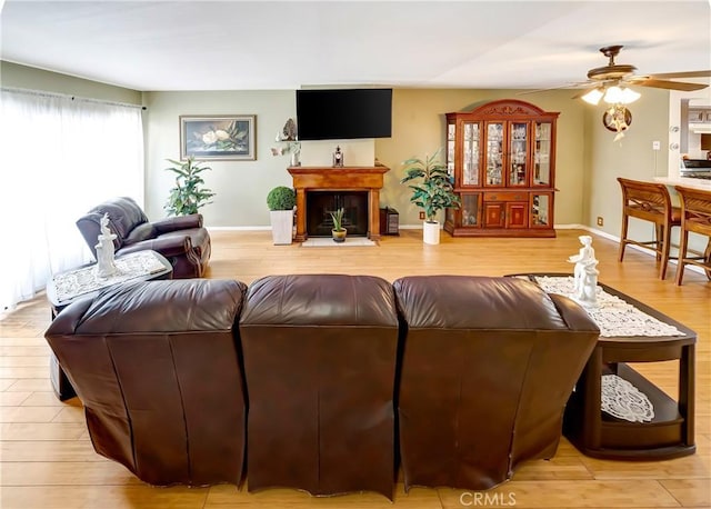 7226 Jordan Ave Unit 6, Canoga Park, CA 91303 - living room featuring a ceiling fan, light wood-type flooring, baseboards, and a fireplace