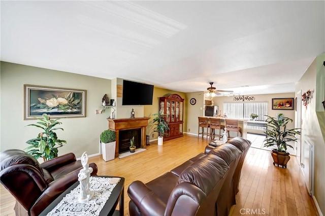 7226 Jordan Ave Unit 6, Canoga Park, CA 91303 - living area featuring a ceiling fan, a fireplace, light wood-style flooring, and baseboards