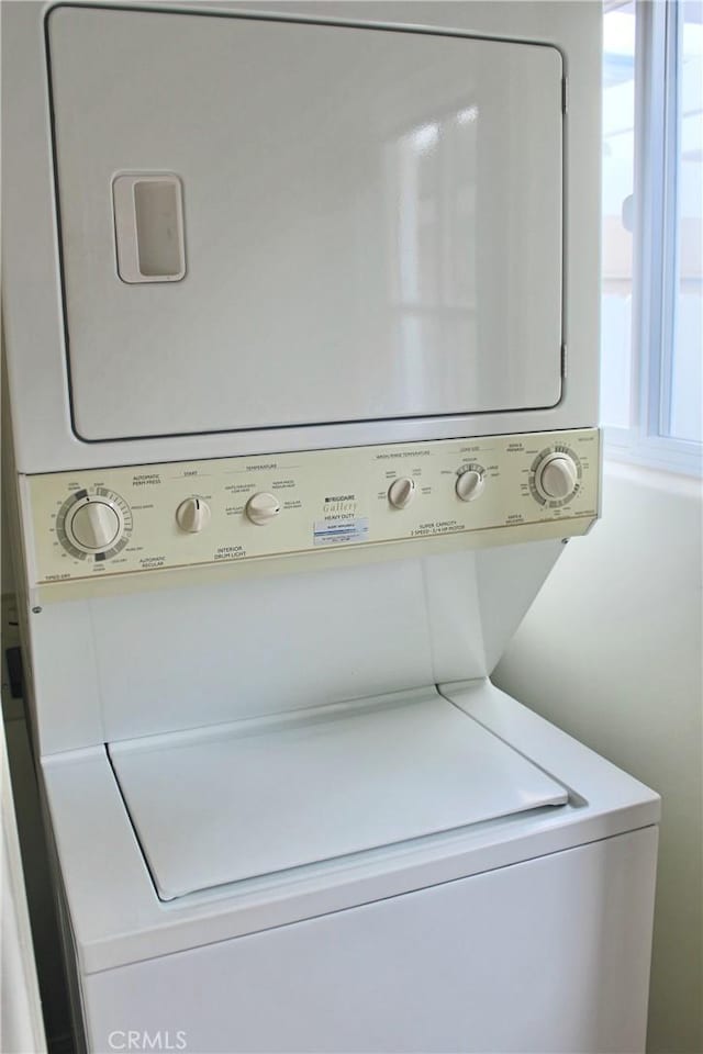 washroom featuring stacked washer and clothes dryer