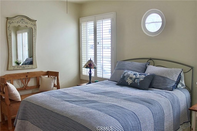 bedroom with multiple windows and wood finished floors