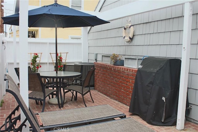 view of patio / terrace with outdoor dining area, central air condition unit, grilling area, and fence