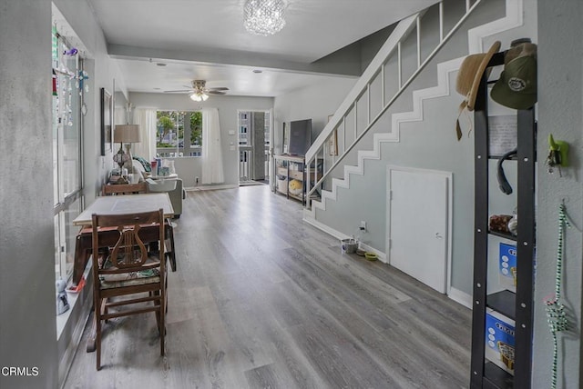 entrance foyer with wood finished floors, stairway, a chandelier, baseboards, and ceiling fan