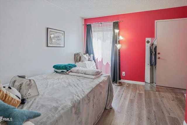 bedroom featuring wood finished floors and a textured ceiling