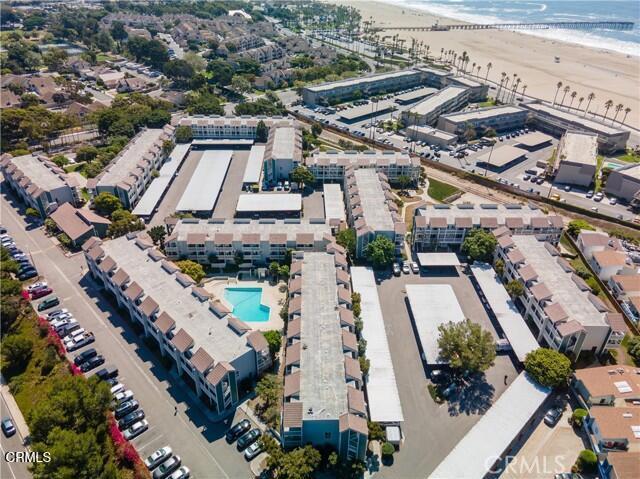 aerial view of property and surrounding area featuring a pool and unending shoreline