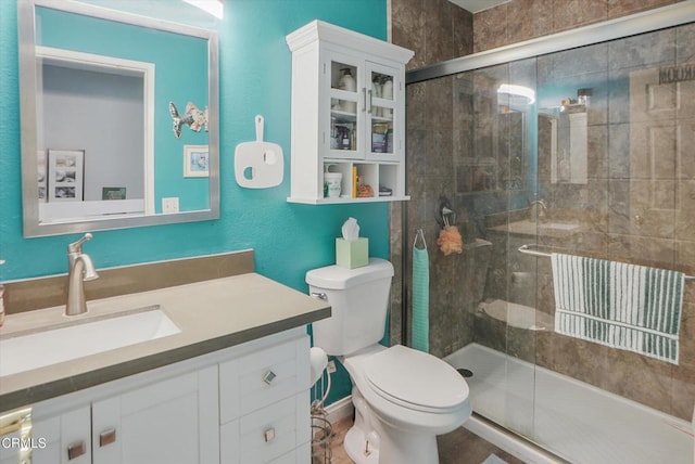 bathroom featuring a stall shower, toilet, and vanity