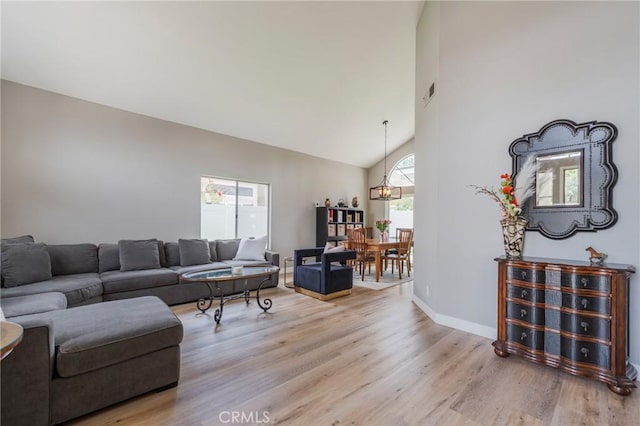 27483 Dandelion Ct, Temecula, CA 92591 - living area featuring light wood finished floors, high vaulted ceiling, baseboards, and a chandelier