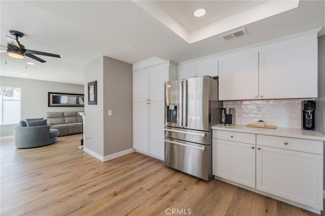 27483 Dandelion Ct, Temecula, CA 92591 - kitchen with stainless steel fridge, decorative backsplash, baseboards, white cabinetry, and light countertops