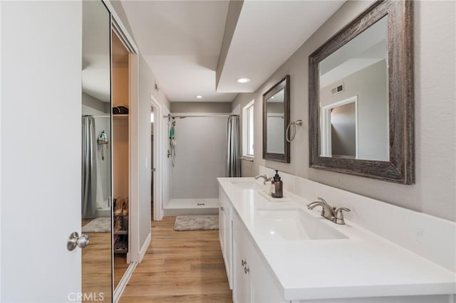 27483 Dandelion Ct, Temecula, CA 92591 - bathroom with wood finished floors, a shower with curtain, double vanity, and recessed lighting