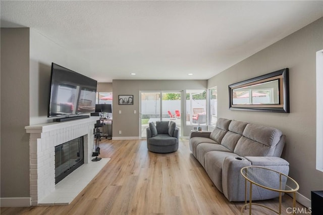 27483 Dandelion Ct, Temecula, CA 92591 - living room featuring light wood-style floors, a fireplace, baseboards, and recessed lighting