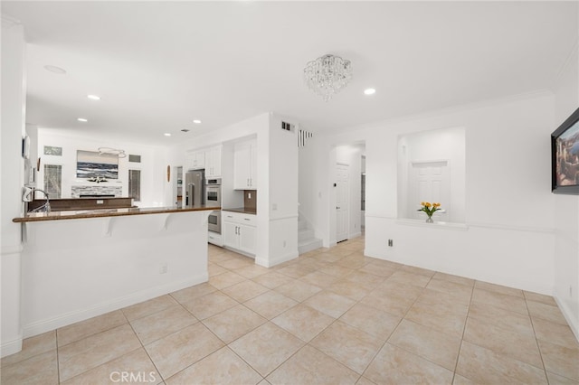 18660 Sunset Knoll Dr, Riverside, CA 92504 - kitchen with stainless steel appliances, dark countertops, white cabinetry, a peninsula, and light tile patterned floors