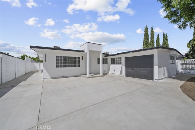 11177 Tamarack Ave, Pacoima, CA 91331 - view of front facade featuring stucco siding, fence, a garage, and driveway
