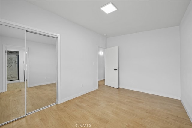 11177 Tamarack Ave, Pacoima, CA 91331 - unfurnished bedroom with light wood-type flooring, baseboards, and a closet