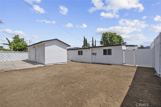 11177 Tamarack Ave, Pacoima, CA 91331 - rear view of property with fence, an outbuilding, a storage shed, and a gate