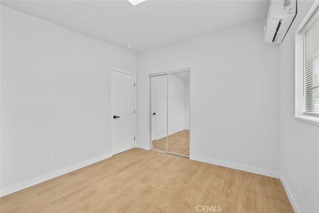 11177 Tamarack Ave, Pacoima, CA 91331 - unfurnished bedroom featuring a wall mounted AC, light wood-style flooring, baseboards, and a closet