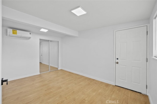 11177 Tamarack Ave, Pacoima, CA 91331 - unfurnished bedroom featuring an AC wall unit, light wood-type flooring, baseboards, and a closet