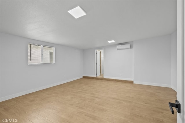 11177 Tamarack Ave, Pacoima, CA 91331 - below grade area with a wall mounted AC, light wood-style flooring, and baseboards