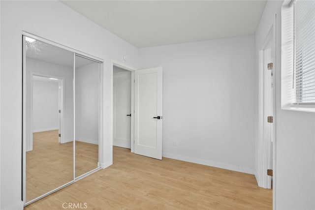 11177 Tamarack Ave, Pacoima, CA 91331 - unfurnished bedroom with light wood-style floors, baseboards, and a closet