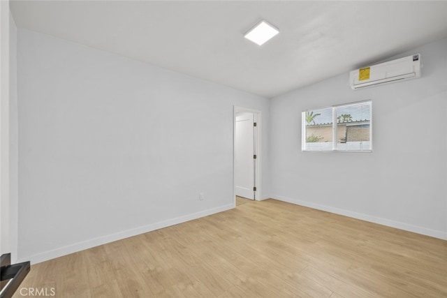 11177 Tamarack Ave, Pacoima, CA 91331 - unfurnished room featuring a wall mounted AC, light wood-style floors, and baseboards