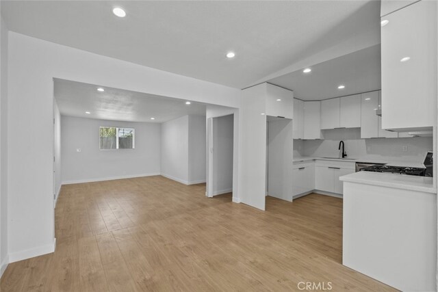 11177 Tamarack Ave, Pacoima, CA 91331 - kitchen featuring a sink, modern cabinets, gas range, white cabinetry, and open floor plan