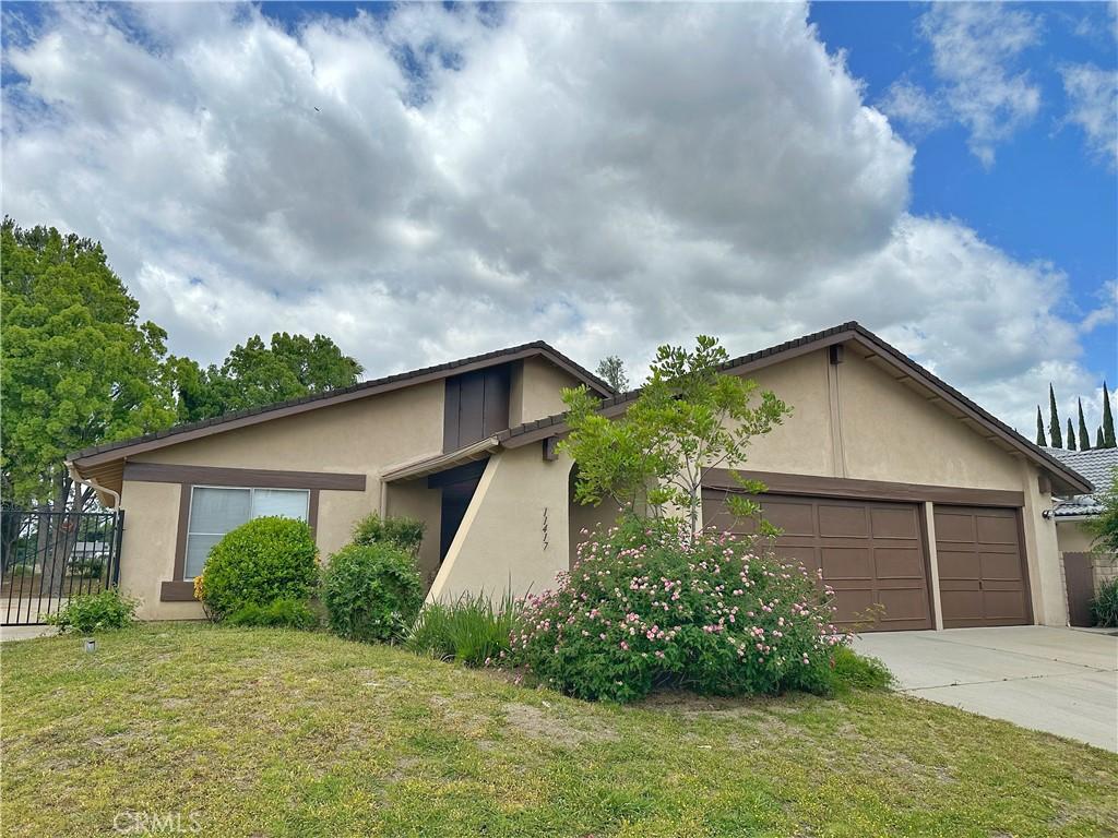 view of front of house with stucco siding, concrete driveway, and an attached garage