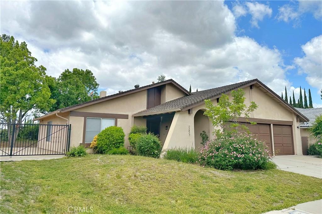 view of front of home with stucco siding, an attached garage, and driveway