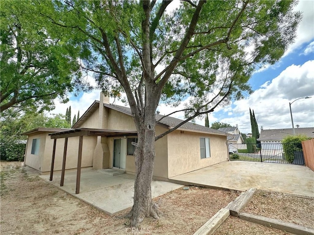rear view of property with a patio and stucco siding