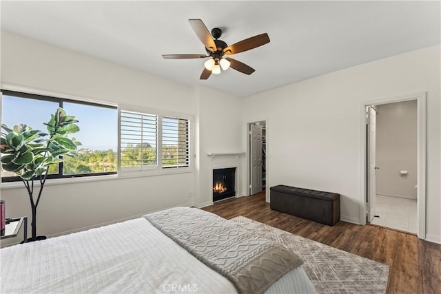 4227 Freedom Dr Unit 304, Calabasas, CA 91302 - bedroom featuring a warm lit fireplace, wood finished floors, baseboards, ceiling fan, and ensuite bath
