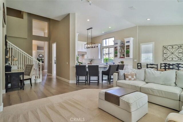 536 Granite Hills St, Simi Valley, CA 93065 - living area featuring stairs, light wood-style floors, lofted ceiling, baseboards, and a chandelier