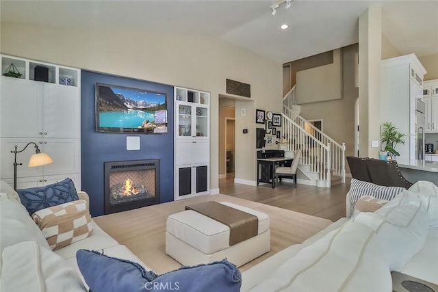 536 Granite Hills St, Simi Valley, CA 93065 - living area featuring stairs, a lit fireplace, wood finished floors, and high vaulted ceiling