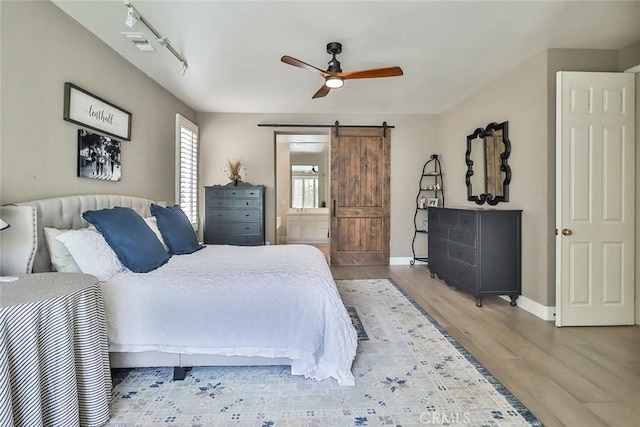 536 Granite Hills St, Simi Valley, CA 93065 - bedroom with a barn door, wood finished floors, baseboards, ensuite bath, and a ceiling fan