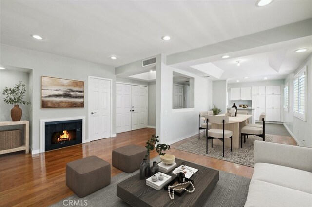 13220 Valleyheart Dr Unit 106, Studio City, CA 91604 - living area with wood finished floors, recessed lighting, baseboards, a lit fireplace, and a tray ceiling
