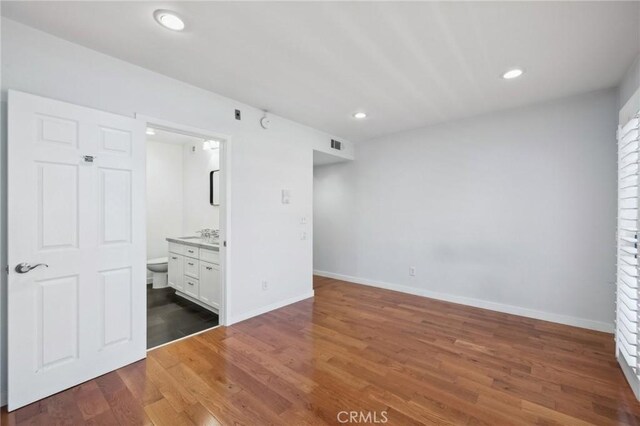 13220 Valleyheart Dr Unit 106, Studio City, CA 91604 - unfurnished bedroom with wood finished floors, recessed lighting, baseboards, and connected bathroom