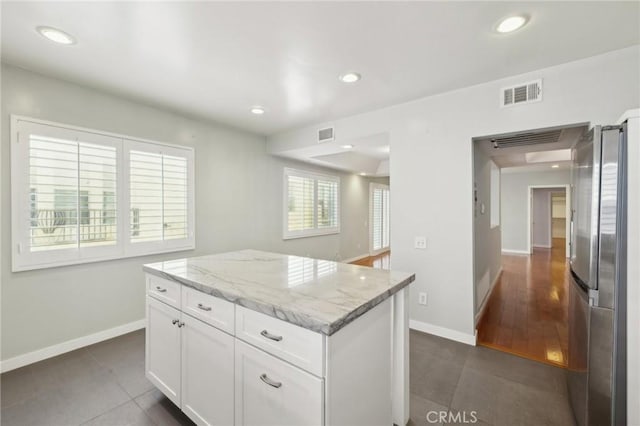 13220 Valleyheart Dr Unit 106, Studio City, CA 91604 - kitchen with freestanding refrigerator, dark tile patterned flooring, white cabinets, light stone counters, and baseboards
