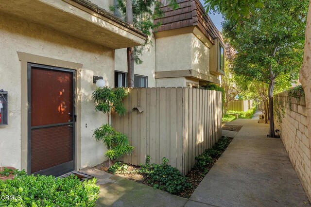 103 E Sierra Madre Blvd Unit E, Sierra Madre, CA 91024 - view of exterior entry featuring stucco siding, fence, and mansard roof