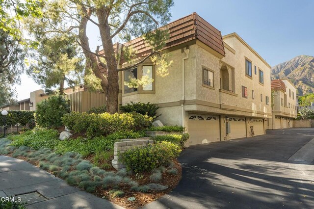 103 E Sierra Madre Blvd Unit E, Sierra Madre, CA 91024 - view of property featuring an attached garage, driveway, and fence