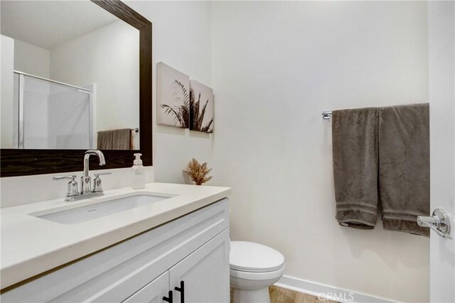 4085 E Liliana Paseo Unit 69, Ontario, CA 91764 - full bathroom with an enclosed shower, toilet, vanity, baseboards, and wood finished floors