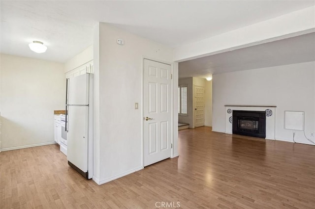 391 Sequoia St Unit 5, Morro Bay, CA 93442 - unfurnished living room featuring light wood finished floors, baseboards, and a fireplace with flush hearth