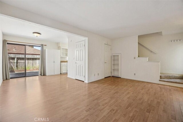 391 Sequoia St Unit 5, Morro Bay, CA 93442 - unfurnished living room featuring light wood finished floors, stairway, and baseboards
