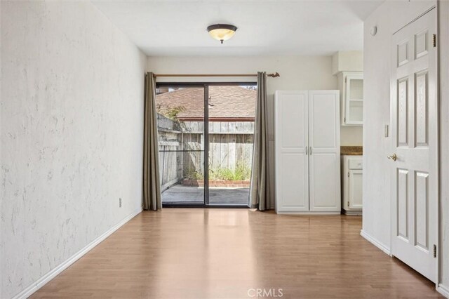 391 Sequoia St Unit 5, Morro Bay, CA 93442 - unfurnished room with wood finished floors, a textured wall, and baseboards