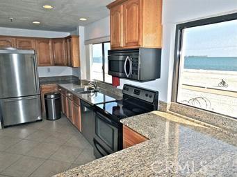 1750 E Ocean Blvd Unit 511, Long Beach, CA 90802 - kitchen featuring appliances with stainless steel finishes, a sink, brown cabinetry, light stone countertops, and recessed lighting